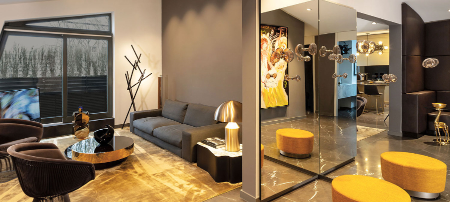 Stylish and elegant Penthouse in Berlin. A spacious living room with a grey sofa, and a spunky yellow carpet. Walls decorated with mirrors.  kitzig design studios Kitzig Design Studios- From Germany to the World Interior Apartment Berlin 01 2 1
