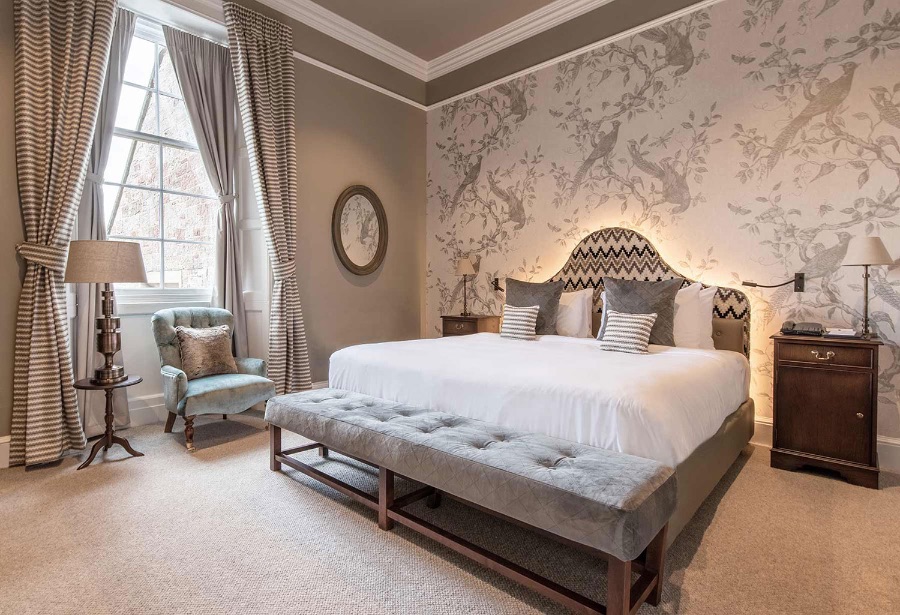 SCHLOSS Roxburghe bedroom, this one decorated in more neutral, smooth tones, featuring a baby blue armchair, and a grey sofa. kitzig design studios Kitzig Design Studios- From Germany to the World Schloss Roxburghe SZ 13 1 1
