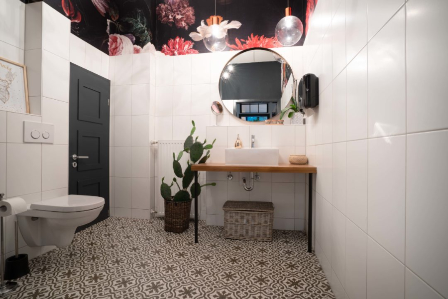 Ivy's Design - The twist we didn't know we needed bathroom decoration. In this image we have two big chandeliers, white tile walls with decorated floor tiles and a round mirror.  ivy's design Ivy’s Design – The twist we didn’t know we needed The Twist of Ivys Design in Modern Interior Decor A WG IN KURFU  RSTENDAMM