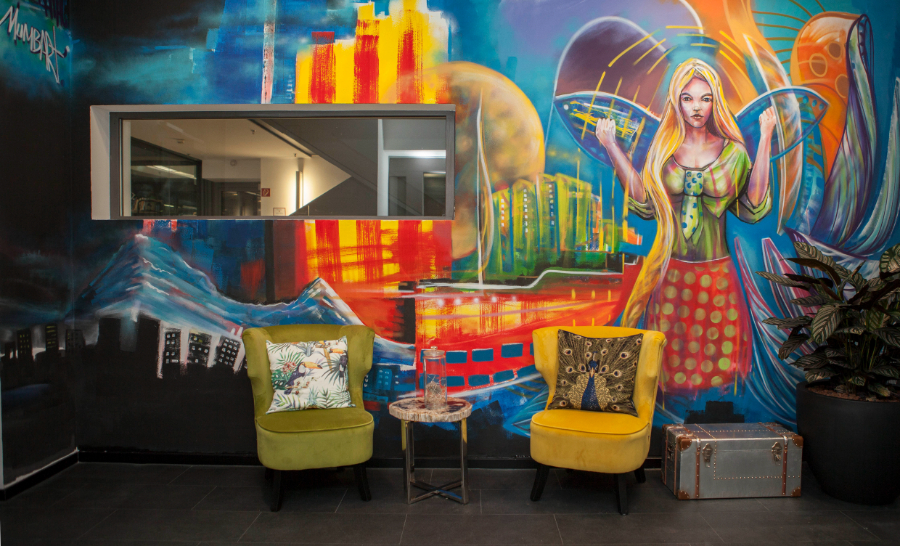 Ivy's Design - The twist we didn't know we needed Alice in Wonderland. A view of a fairy like creature painted on the wall with two different colored armchairs in front of it.  ivy's design Ivy’s Design – The twist we didn’t know we needed The Twist of Ivys Design in Modern Interior Decor Alice in Wonderland interior decoration
