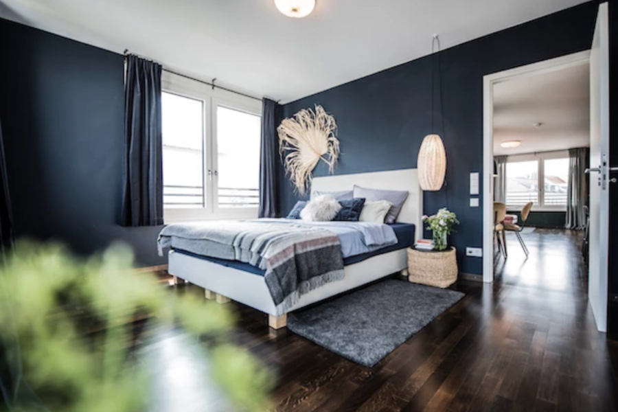 Casa Coulon- Interior Design Inspirations for Your Home APARTMENT MÜNCHEN bedroom in a blue tone, with a grey rug and dark walls. casa coulon Casa Coulon- Interior Design Inspirations for Your Home Captura de ecra   2021 11 19 a  s 15