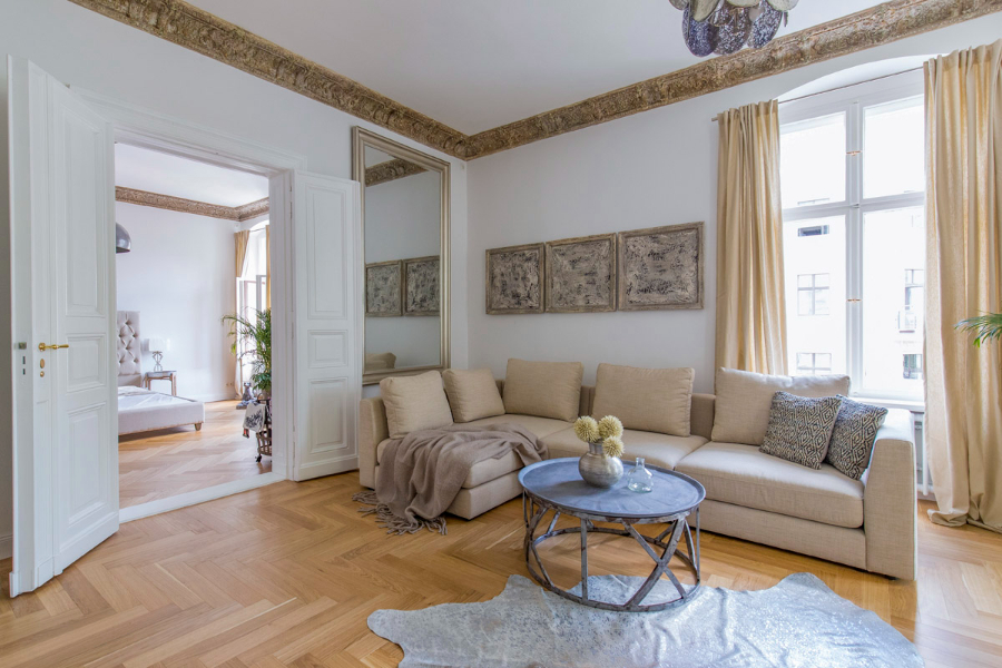 Altberliner Wohnung linving room with a beige sofa, a round coffee table and with a sofa underneath.  the stilschmiede berlin The Stilschmiede Berlin- Interior Design Inspirations BB Inspiartiosn and Ideas stilschmiede berlin portfolio altberliner wohnung 02