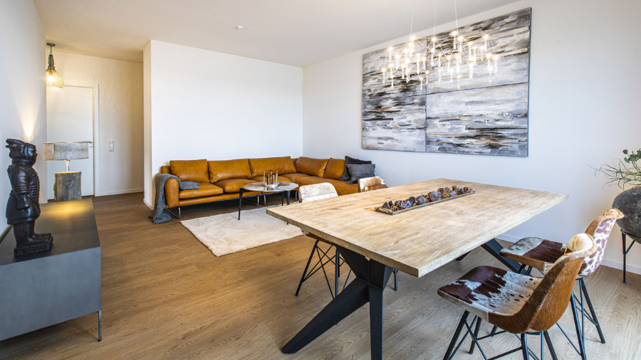Wohnung im Neubau living roo with a yellow mustard sofa, 2 dinin chairs with cow print, a light wood dining table, a white rug with a center table on top of it right next to the sofa and a stunning chandelier.  the stilschmiede berlin The Stilschmiede Berlin- Interior Design Inspirations BB Inspiartiosn and Ideas stilschmiede berlin portfolio wohnung marzahn 01