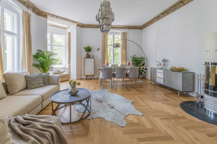 Altberliner Wohnung dining room and living room. We can see a beautiful mettalic chandeleir, a dining table with 6 dining chairs around it, we also have a peak of the fire place. the stilschmiede berlin The Stilschmiede Berlin- Interior Design Inspirations BB Inspiartiosn and Ideasstilschmiede berlin portfolio altberliner wohnung 01