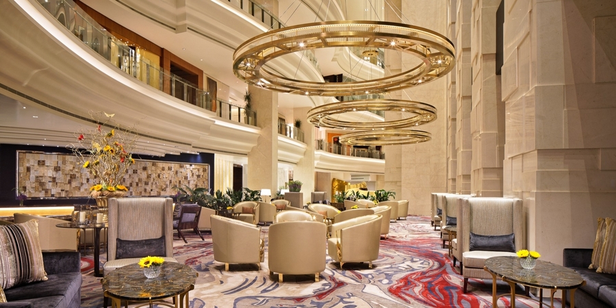 An open space living room with gold details, bespoke leather upholstery and custom wood tables. hba HBA – The Best Interior Design Projects in Dubai HBA1