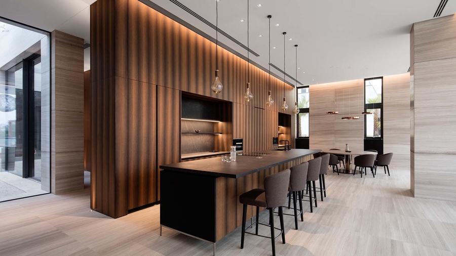 A dining room with earth colours, some custom bar stools, a kitchen counter and dining chairs. anarchitect ANARCHITECT – Best Interior Design Inspirations Webp