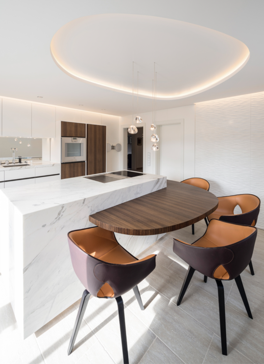ITALIAN TOUCH project from Reimann for modern interior design ideas, kitchen space with a white marble kitchen, some suspension lights, 4 counter stools in a leather, material and a brownish colour. modern interior design ideas Reimann Architecture: Modern Interior Design Ideas italian touch 01  Reimann Architecture Modern Interior Design Ideas